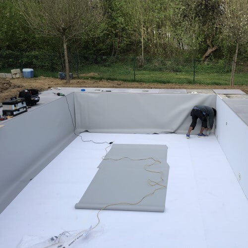 Technicien Aqua Confort installant un liner de piscine